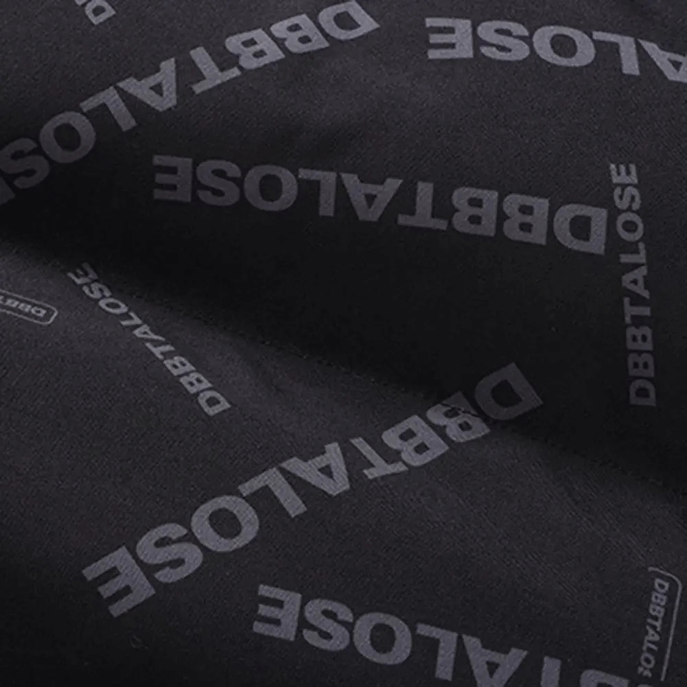 Close-up of black fabric with 'DBBTALOSE' text pattern, part of men's insulated puffer vest, SF1935, stylish winter outerwear.